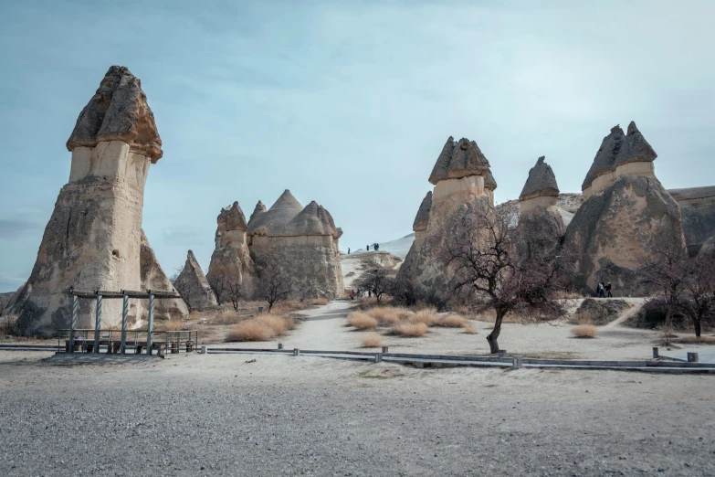 old stone structures in the desert with a few people standing by