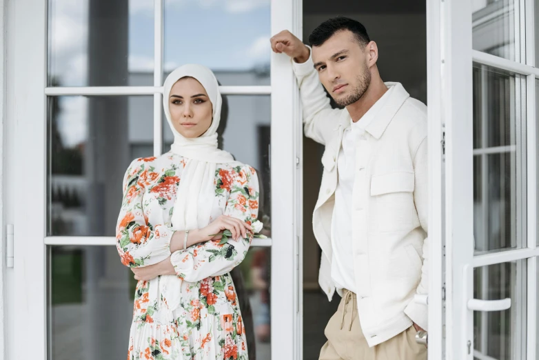 a woman wearing a headscarf next to a man in a floral suit