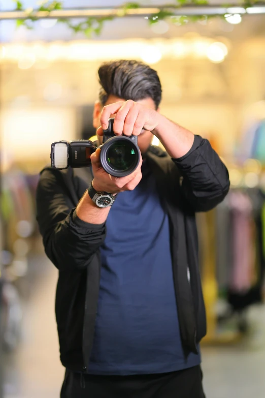 a man in black jacket holding up camera to take a picture