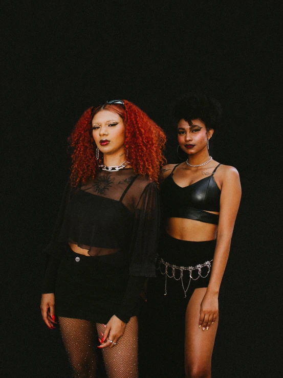 two woman with red hair wearing black outfits