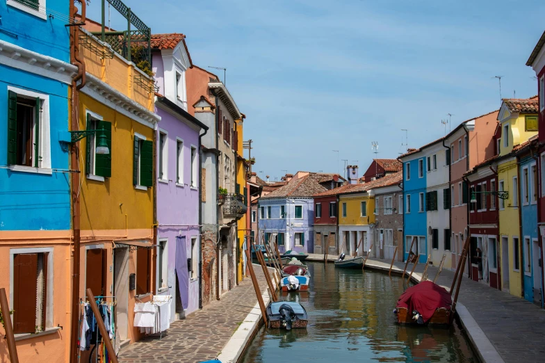 boats are moving down the canals next to colorful buildings