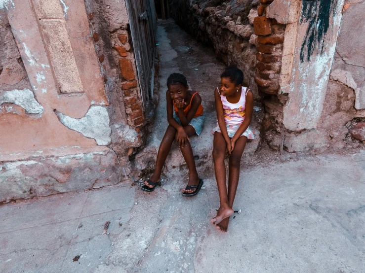 two s sitting against a stone wall