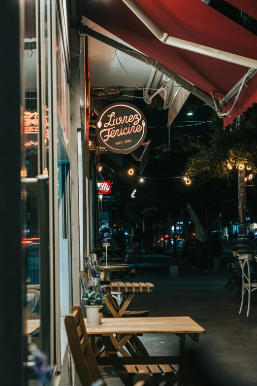 a table and bench are outside of the restaurant