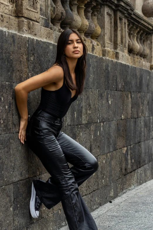 a young woman is leaning up against a wall