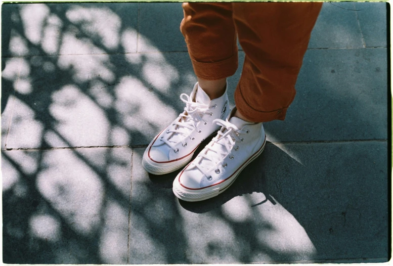 an upper view of someone wearing brown pants and white tennis shoes