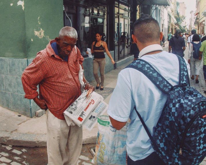 a man is handing out trash to a woman on the street