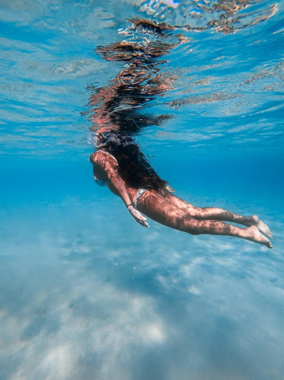 a man in a swimming suit snoraks under the water