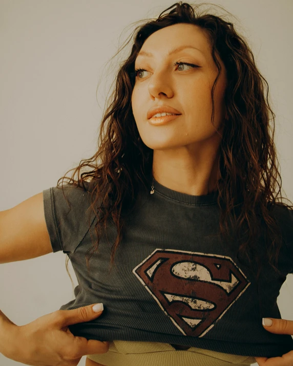 a woman standing wearing a batman t - shirt