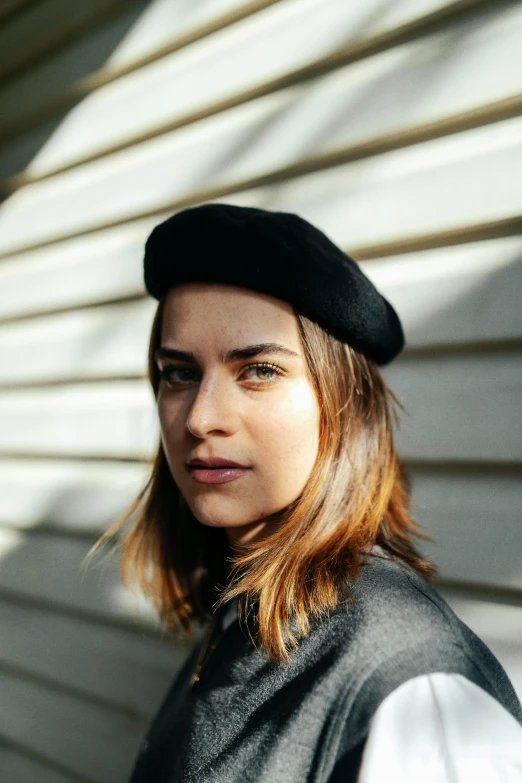 a woman wearing a black hat and gray shirt