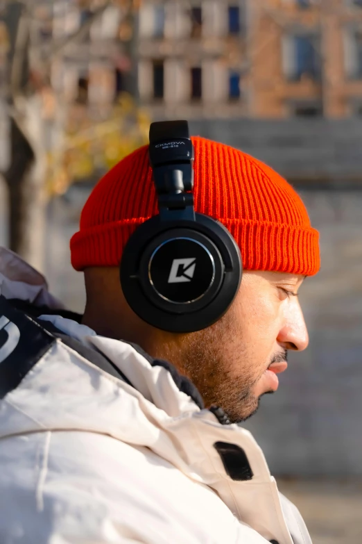 the man wears an orange hat and headphones