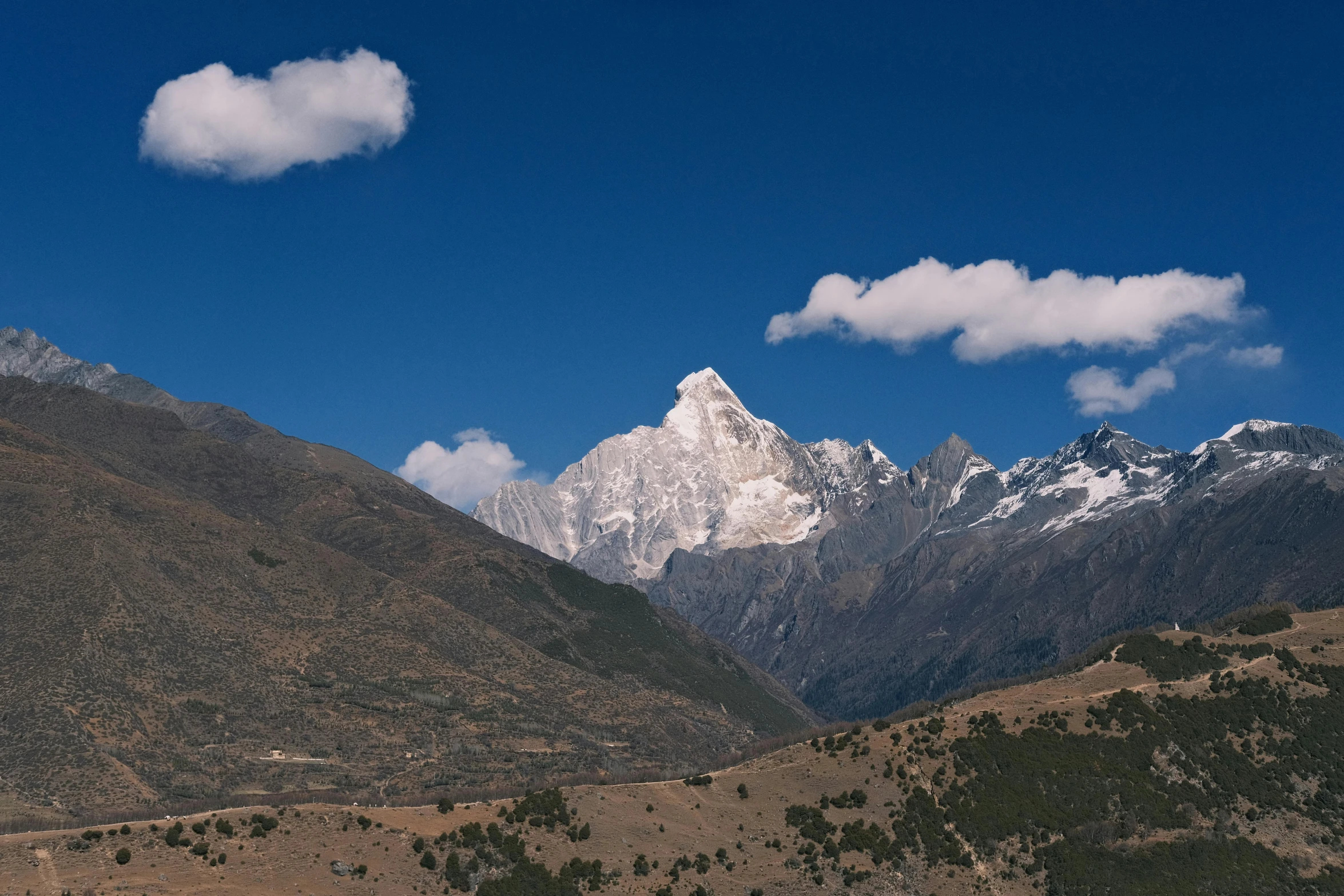 mountains and trees covered with snow and clouds in the background