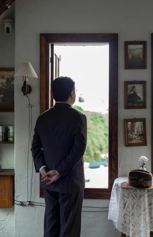 a man in a suit looking out the window