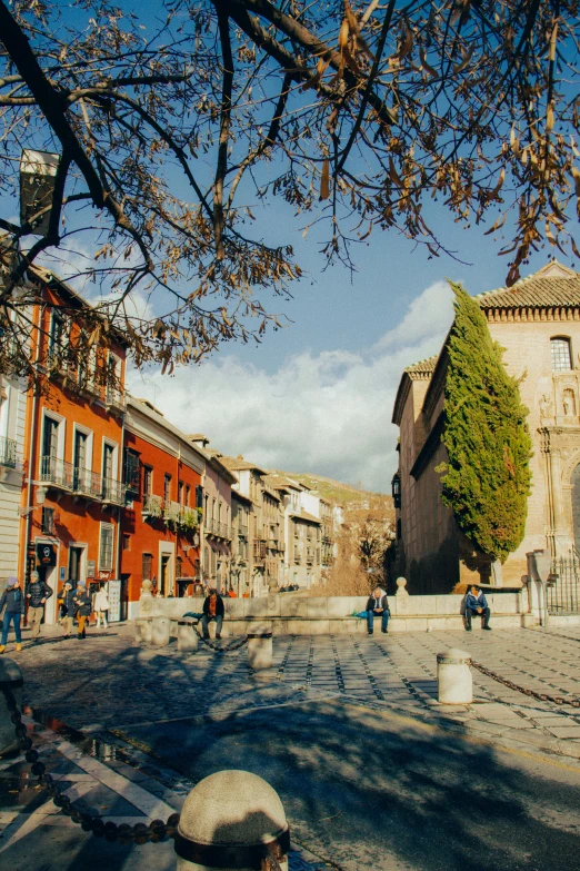 people are walking down the cobblestone streets in an old town