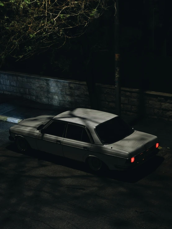 the car is parked along side the street at night