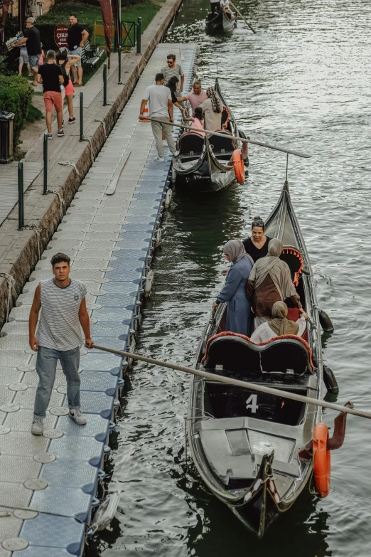 two small boats, one being pulled down the river by a rope