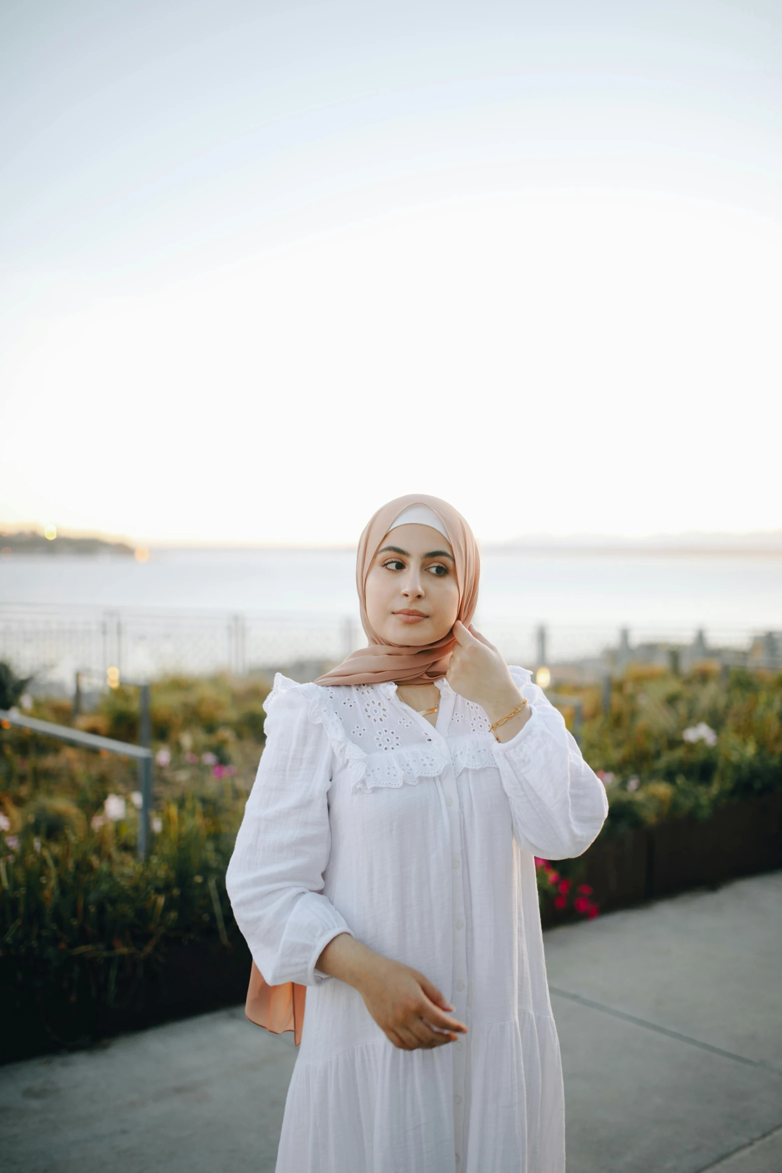 a woman in white is standing next to the ocean