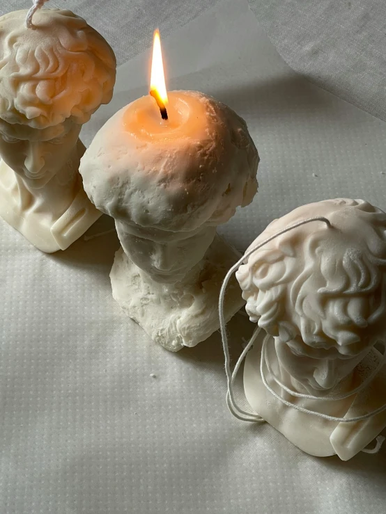 a candle that is next to some statues