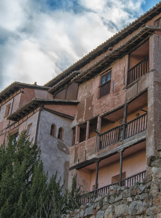 a group of balconies on a building that has stone walls and windows