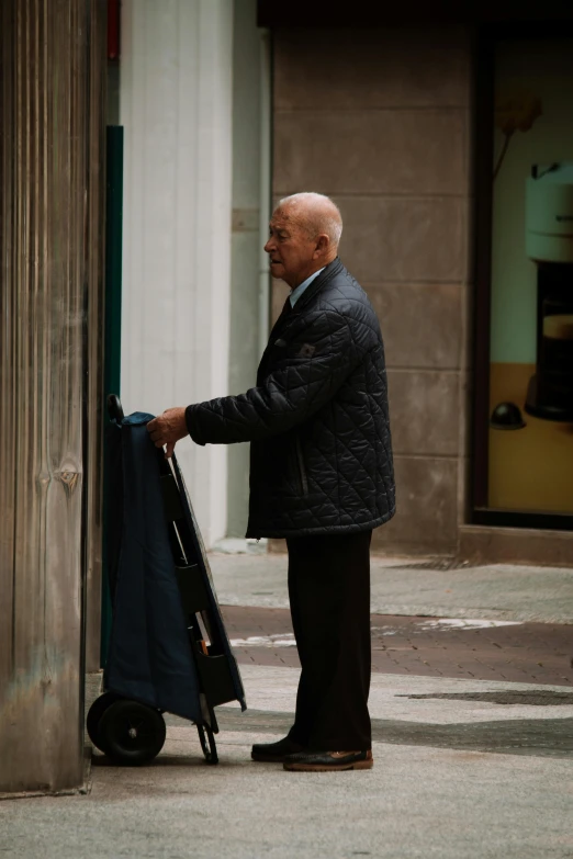 an older man holding a stroller and standing outside