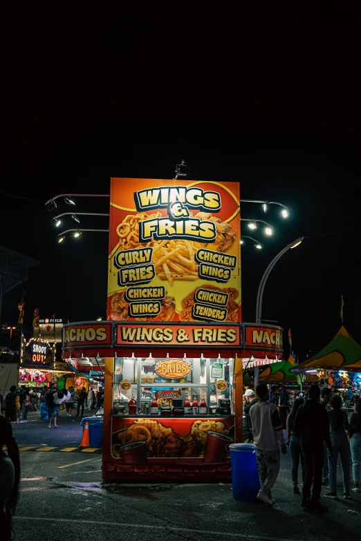 a group of people standing outside of a food cart