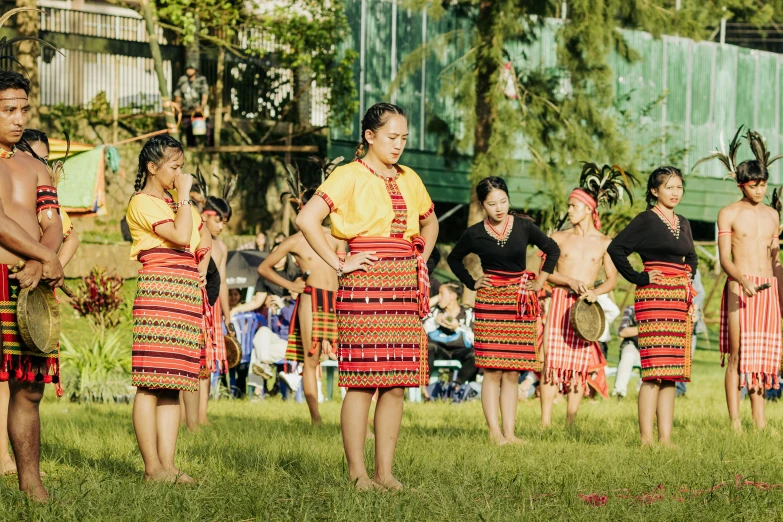 men are performing a traditional dance in the grass