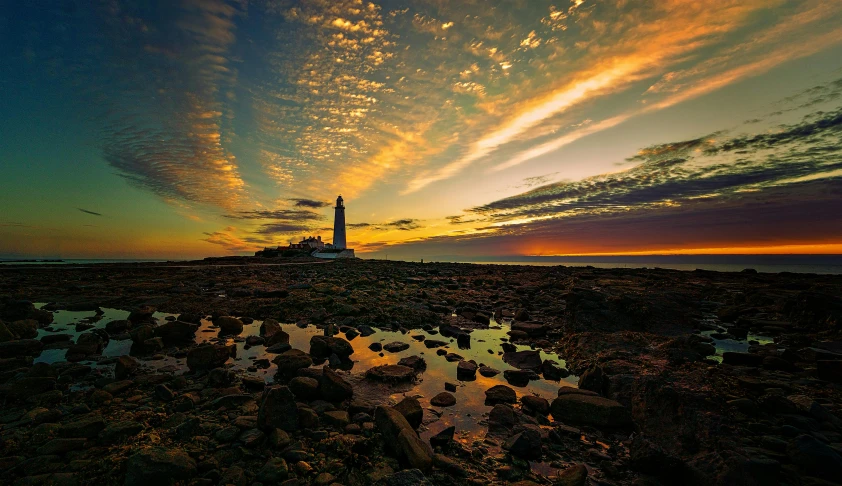 the lighthouse is silhouetted against the sky at twilight