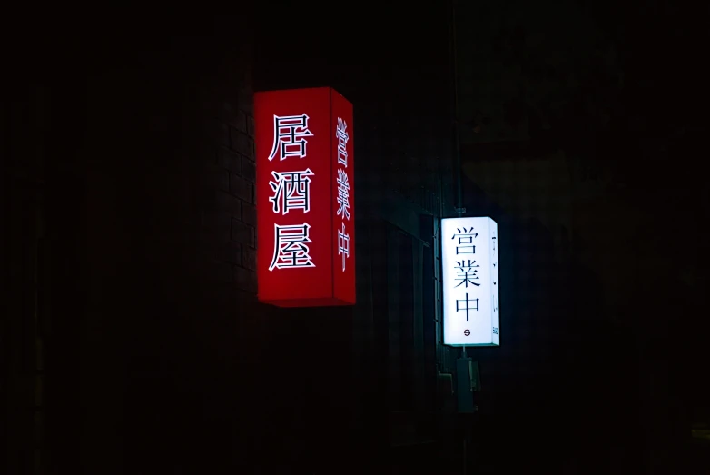 two large signs are shown on a dark street