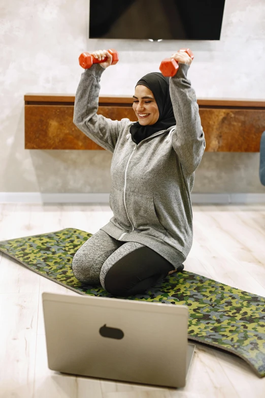 a woman is on a mat with two dumbs in front of her