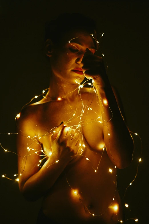 a woman is wearing some string lights around her chest