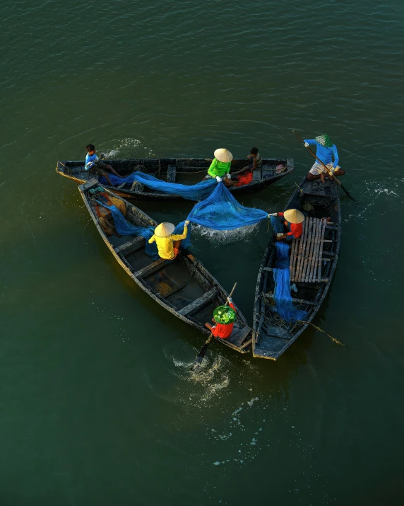 three people standing on the end of a boat floating on top of water