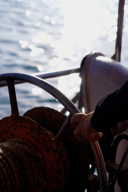 a person on a boat pulls a steering wheel towards the ocean