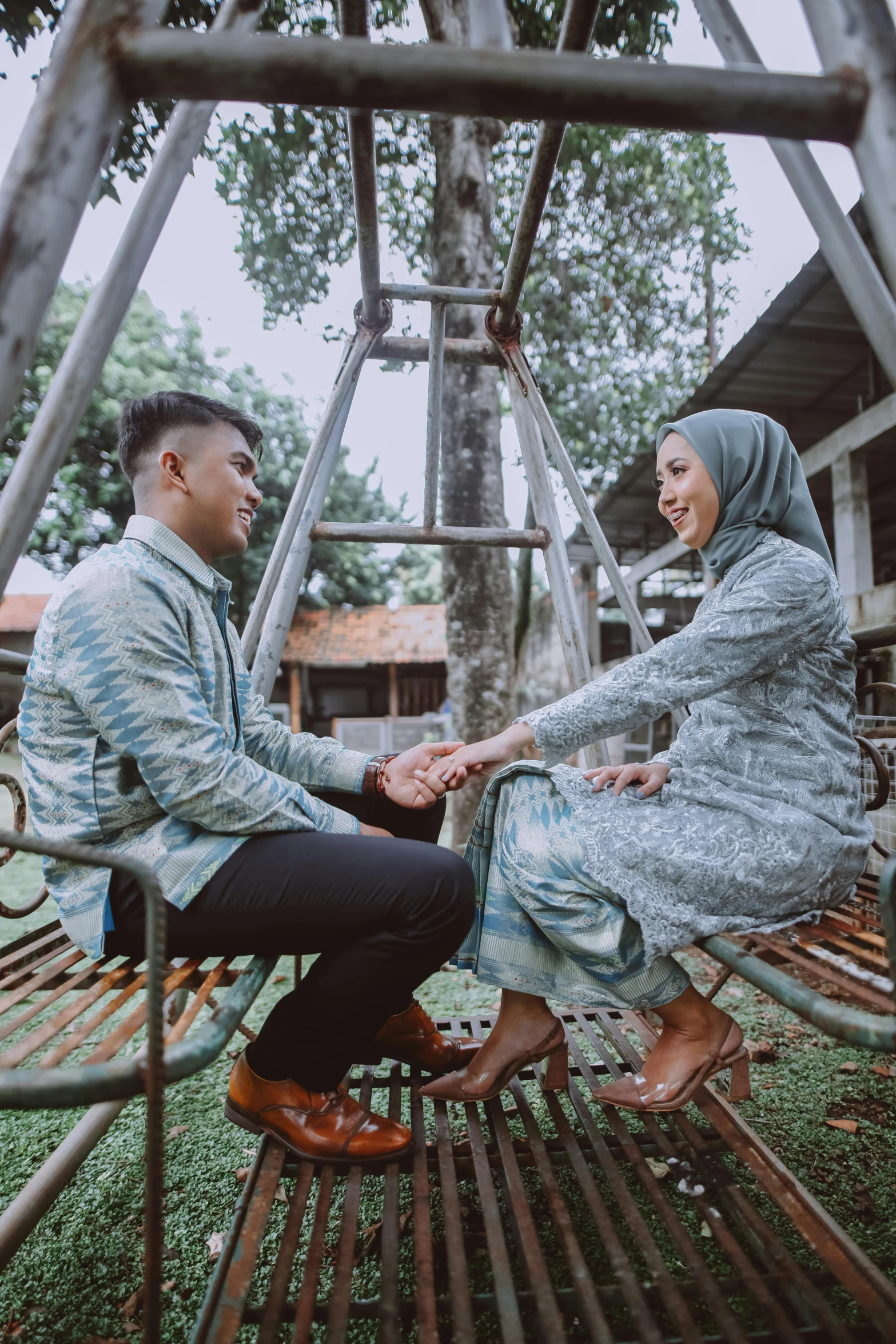 man and woman sitting on a swing set together