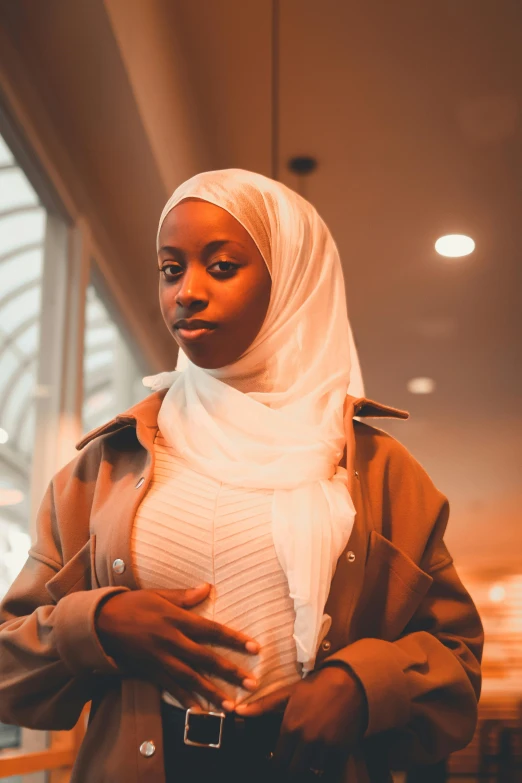 a person with a headscarf standing in a lobby