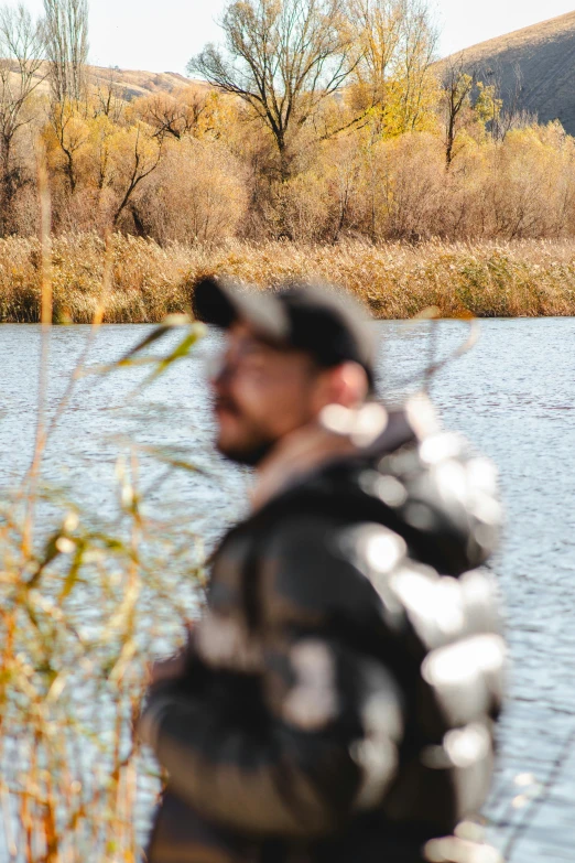 a man stands at the edge of a lake