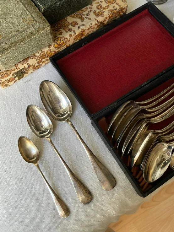 an assortment of spoons and forks on a table