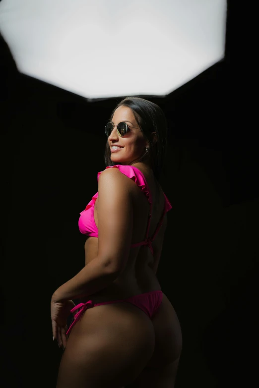 a lady in a bright pink bikini posing