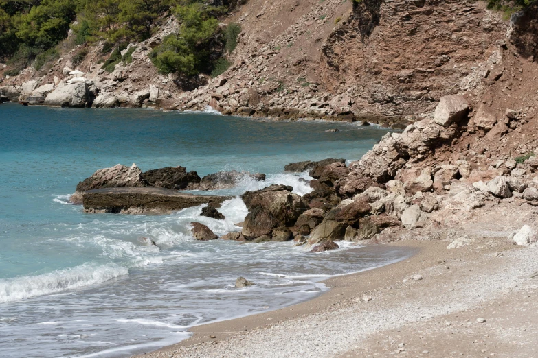 a beach and cliff with some water