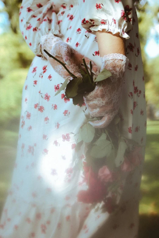 the girl in the long white dress is holding flowers