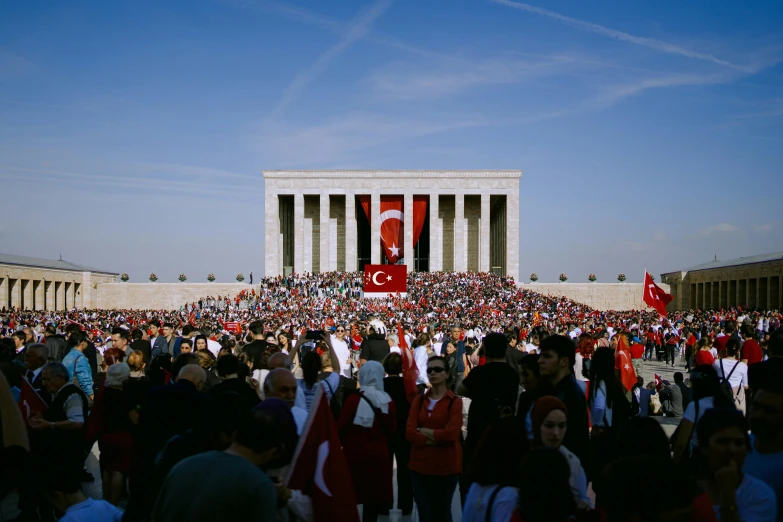 an outdoor gathering in front of an ancient monument