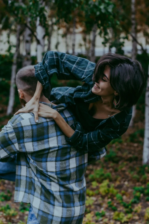 a woman standing next to a boy in the woods