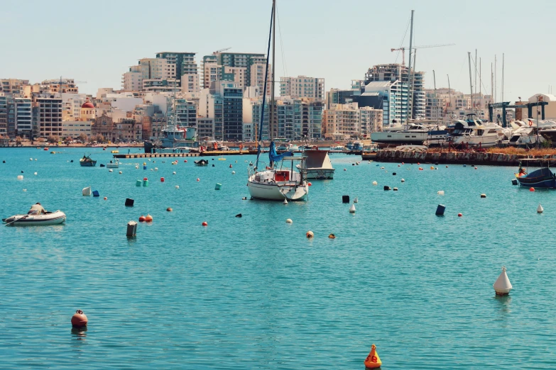 many boats out in the water near some buildings