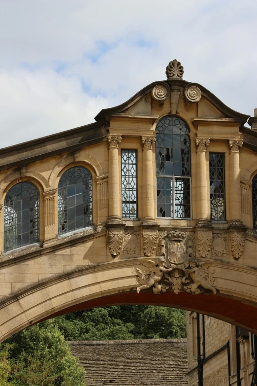 arched stone archway with several windows and statues above