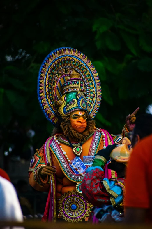 man in colorful headdress with a beard holding soing