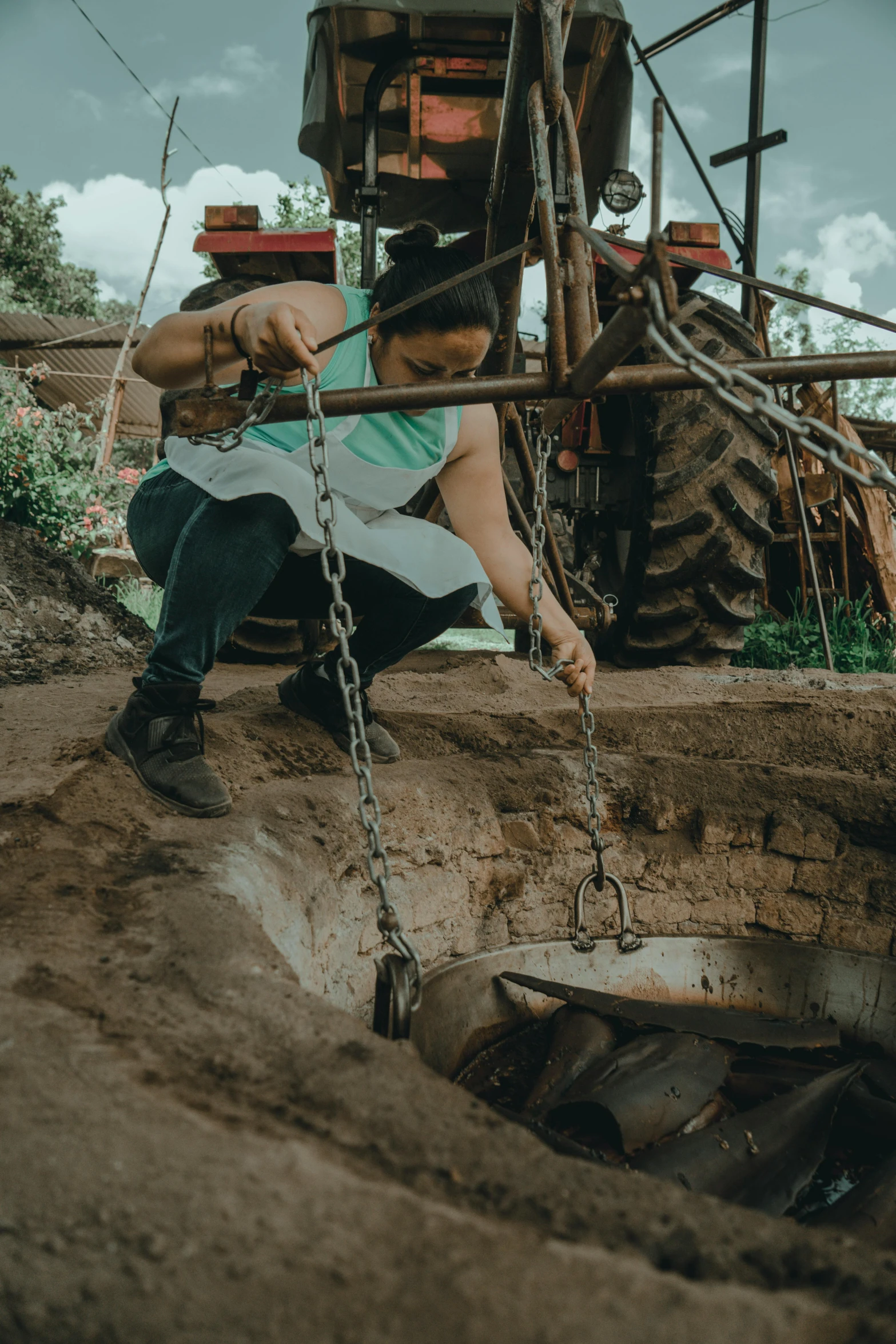 a woman is  to a forklift in front of a large tire