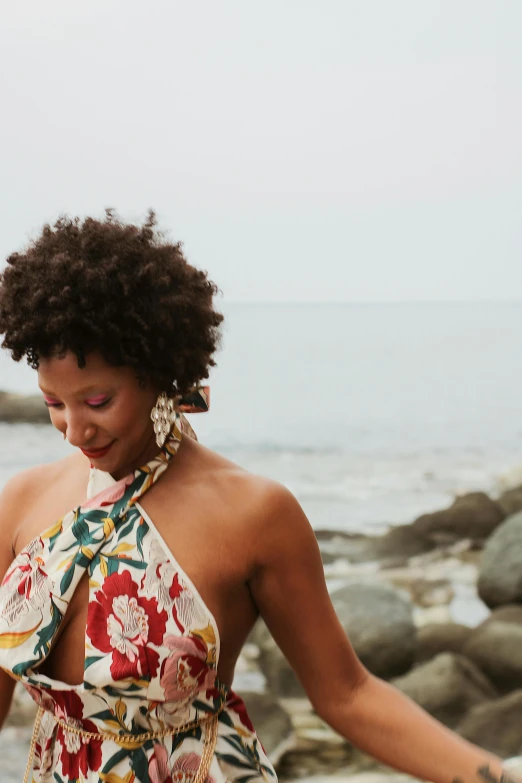 a lady that is standing on a rocky beach