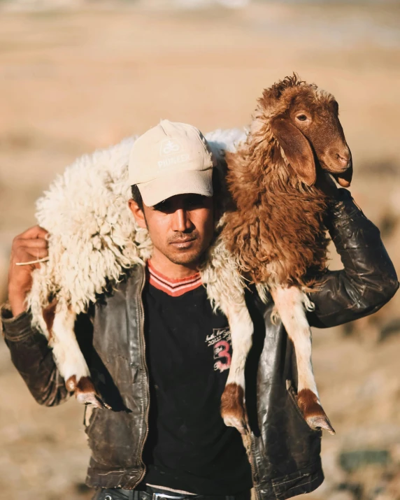 a man carrying a goat across an open plain