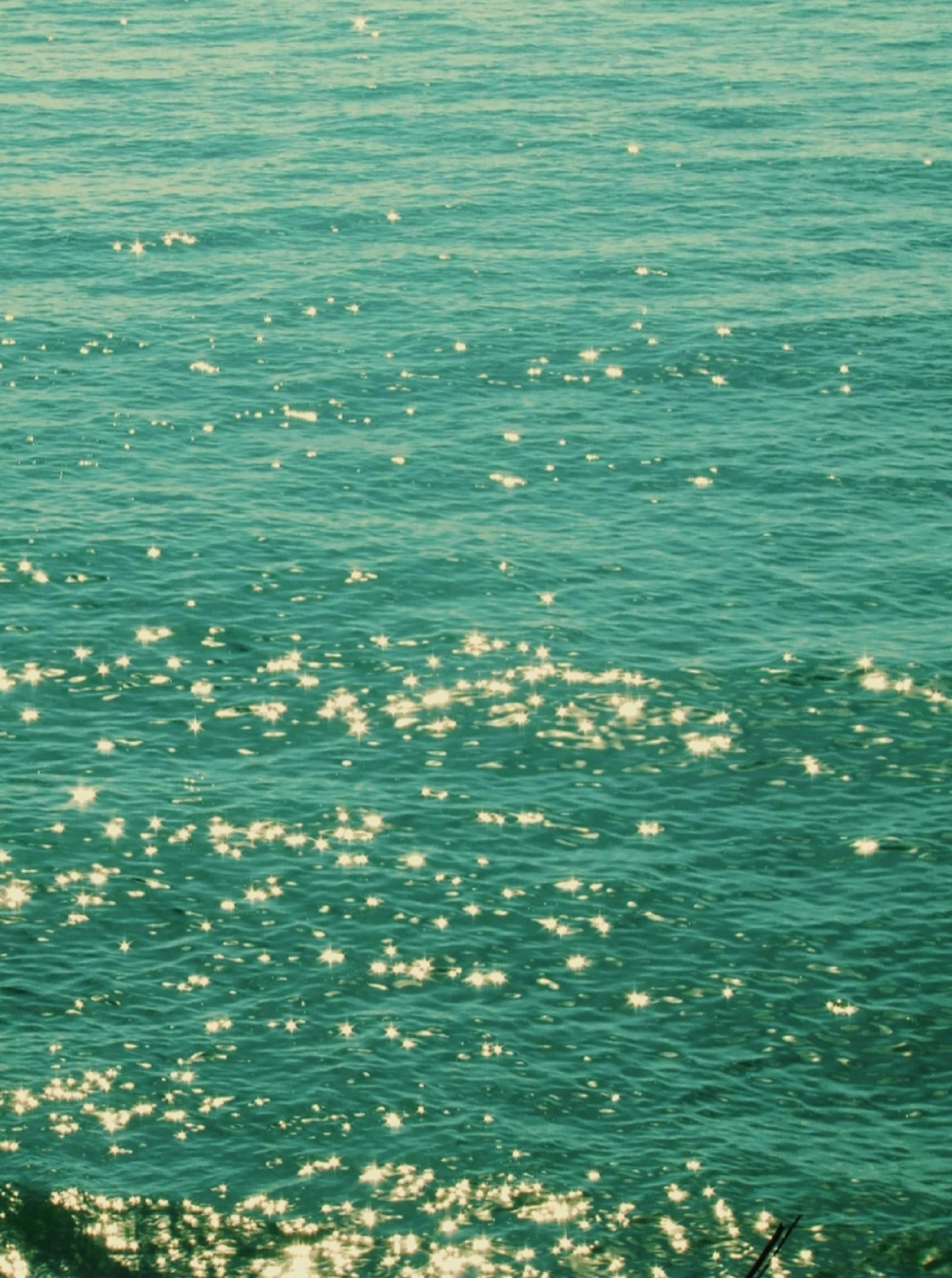 a surfer carries his board through the ocean waves