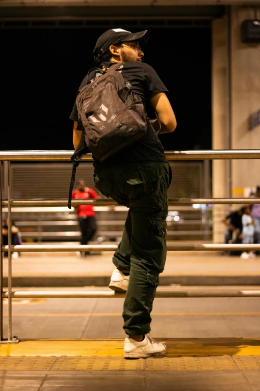 a man is walking with a backpack while on his cellphone