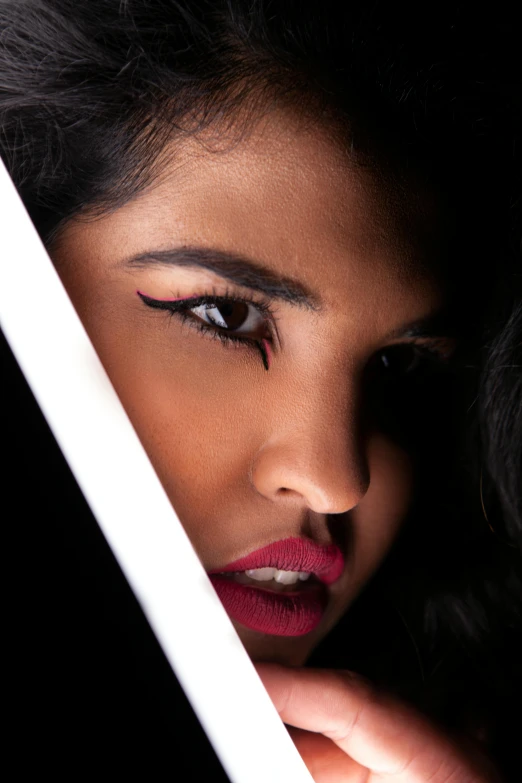 woman holding white sword in front of black background