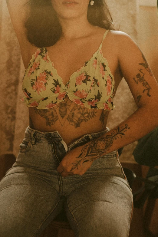 a woman with tattoos and a floral shirt